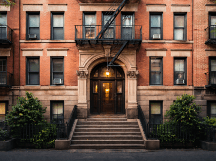 Exterior of a New York multi-unit apartment building representing housing compliance and biohazard remediation risk assessment.